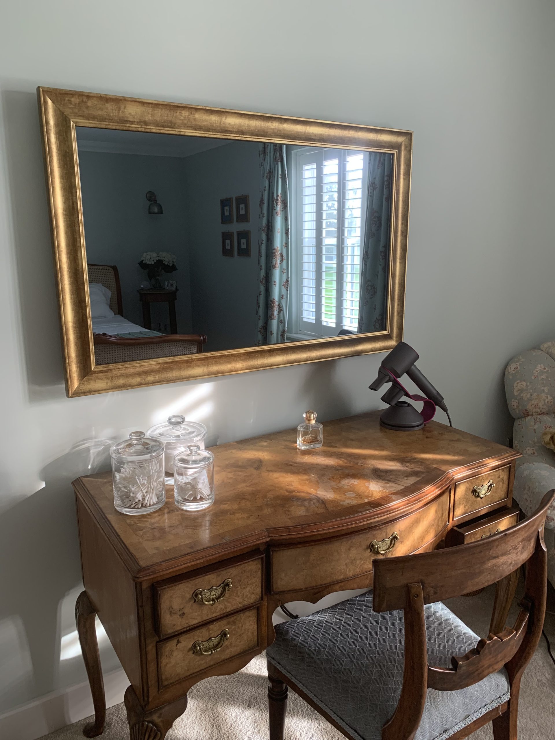 Gold Framed Mirror TV behind a dresser